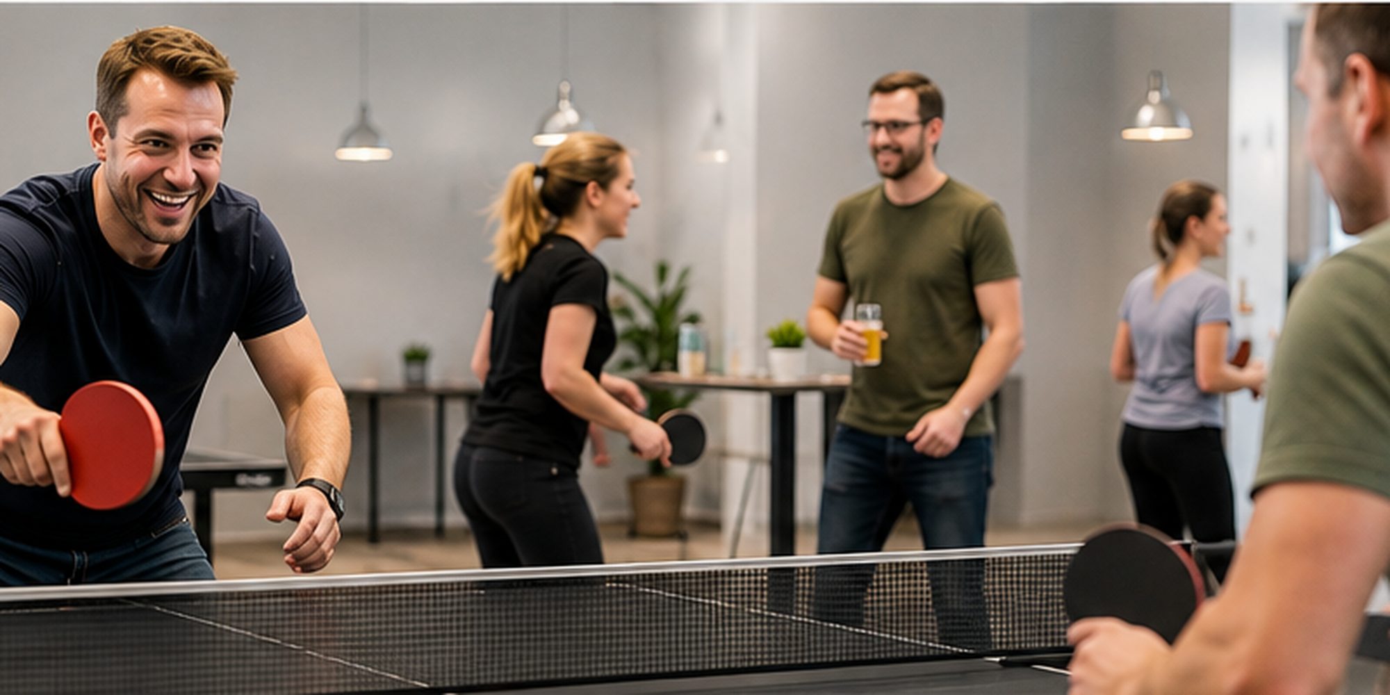 Firmenteam beim Tischtennis in heller moderner Indoor-Atmosphäre