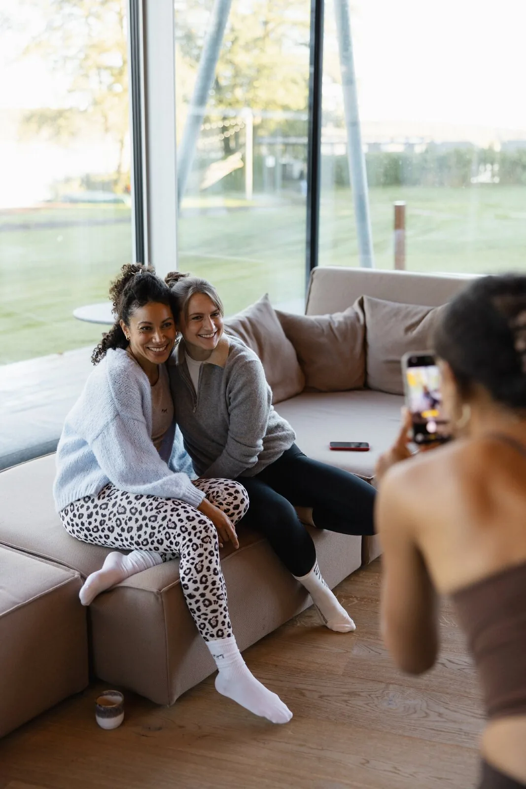 Zwei Freundinnen lachend auf dem Sofa mit Blick auf den Bistensee