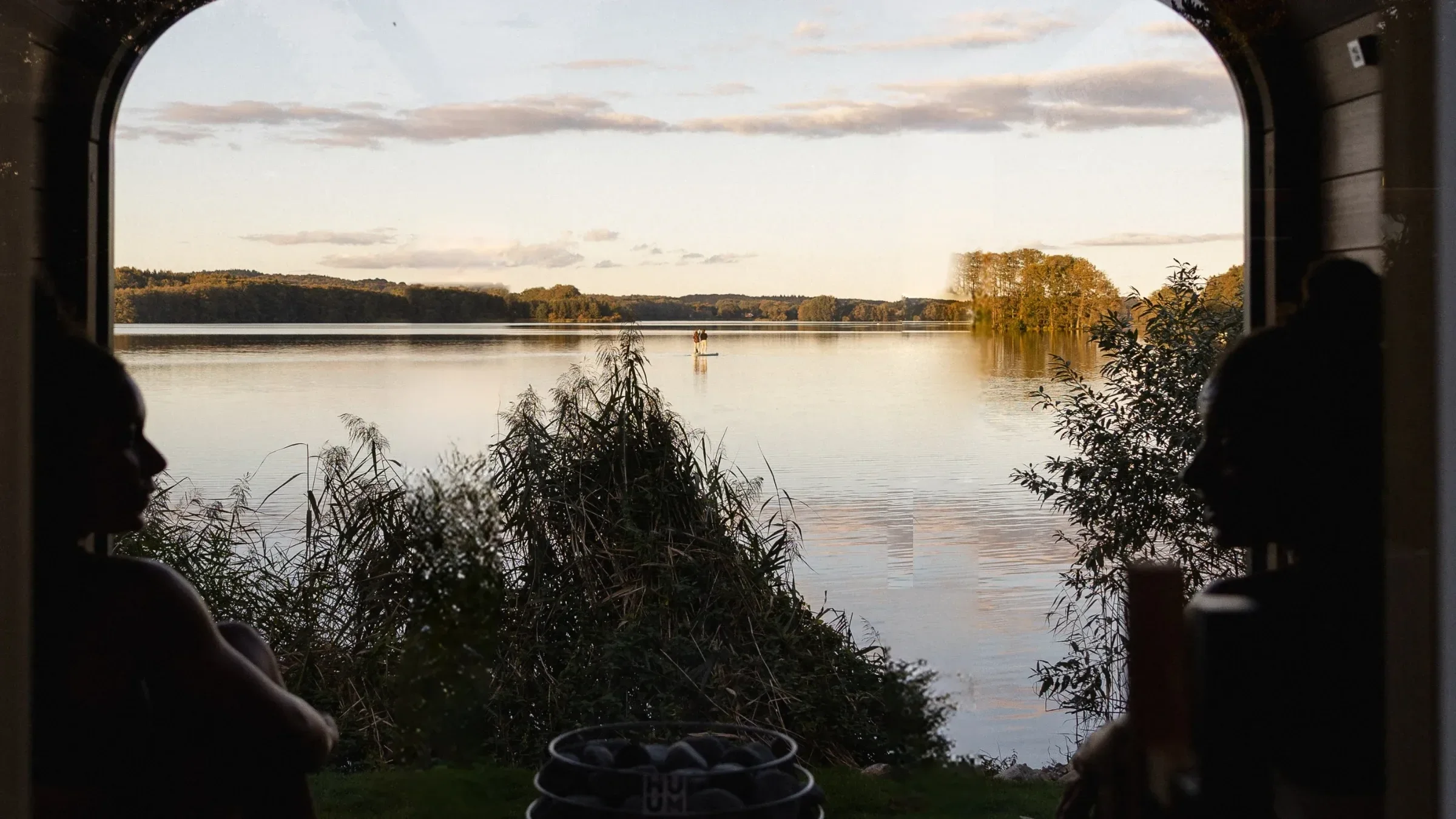 Blick aus dem Saunafenster auf den Bistensee mit SUP im Herbst