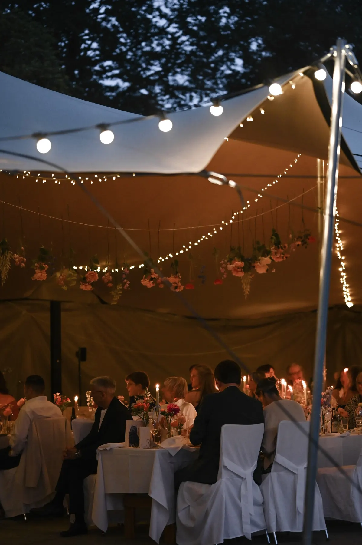 Abendessen im Gartenzelt unter Lichterketten