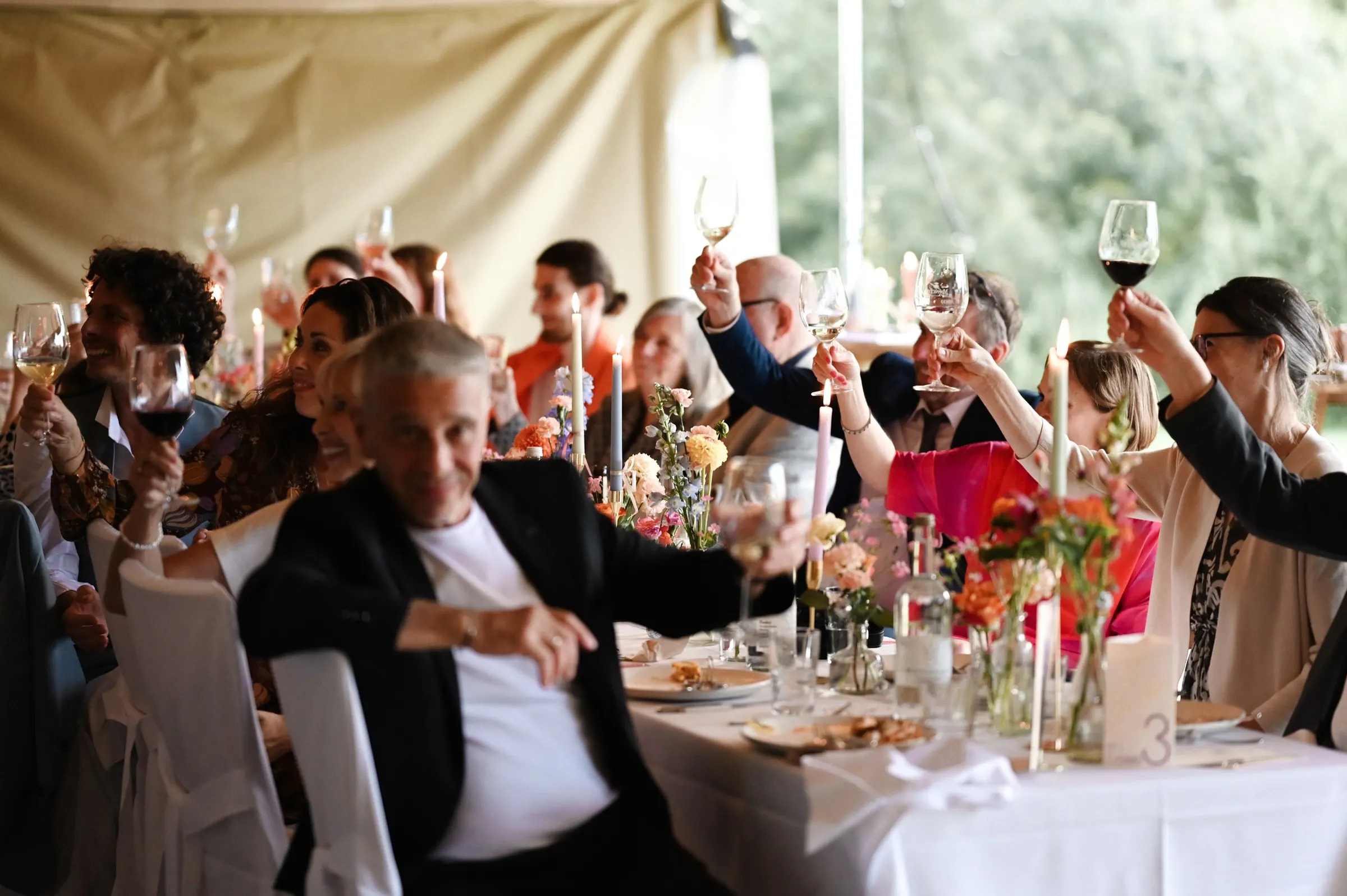 Rede und Anstoßen beim Abendessen im Gartenzelt
