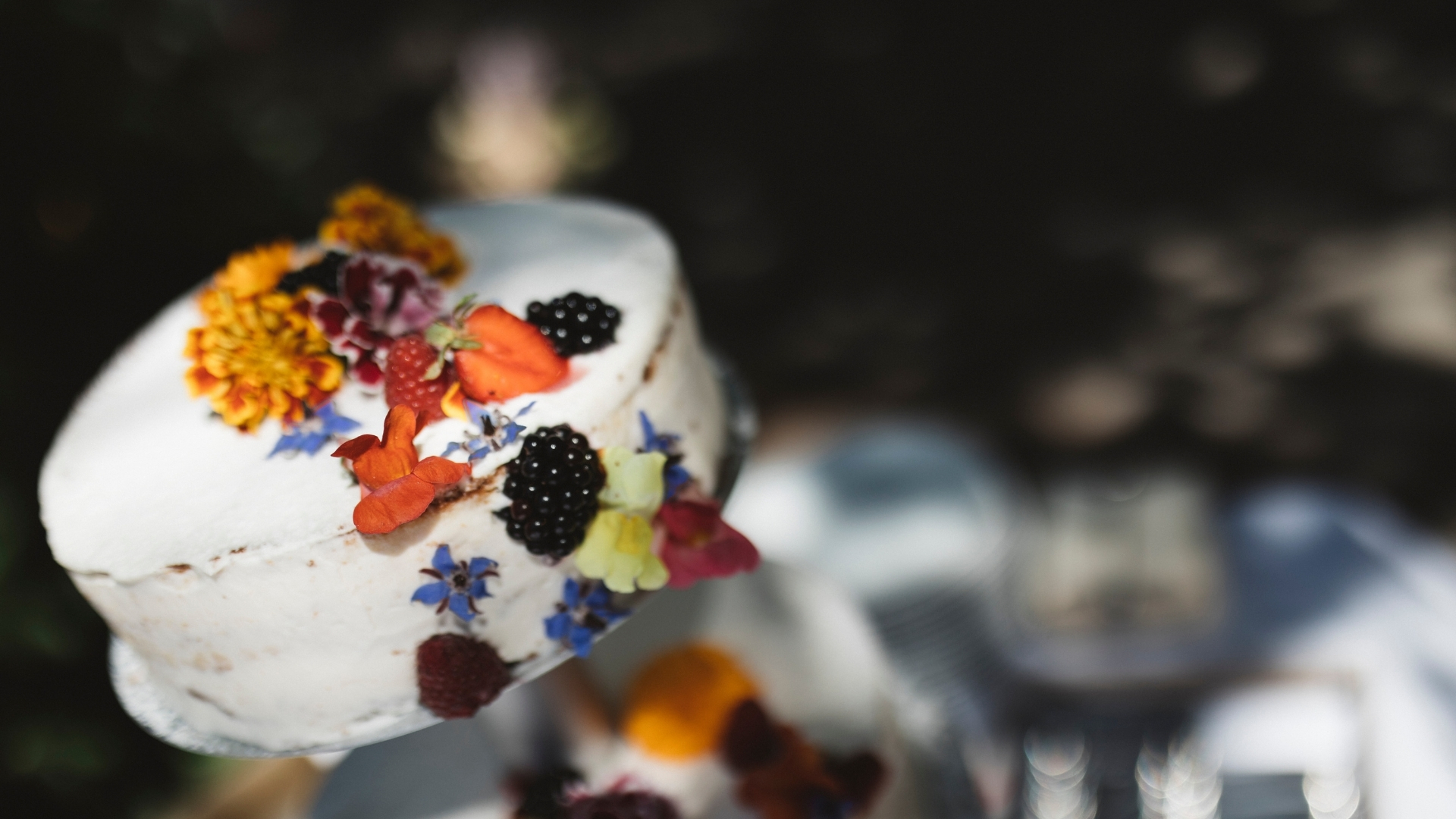 Hochzeitstorte mit essbaren Blüten und Beeren als Dekoration - Seehotel Töpferhaus in Schleswig-Holstein